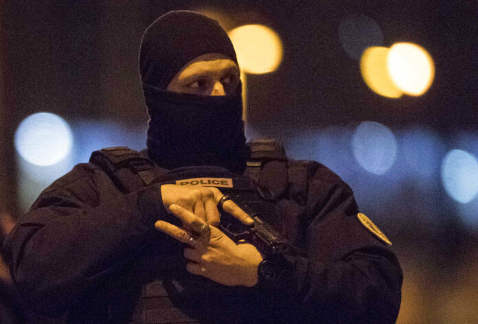 A hooded police officer holds his gun Thursday in Strasbourg, eastern France. Photo: Jean-Francois Badias / Associated Press