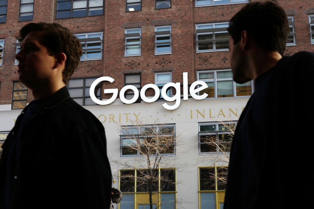 People walk by Google offices in 2017 in New York. Photo: Mark Lennihan / Associated Press