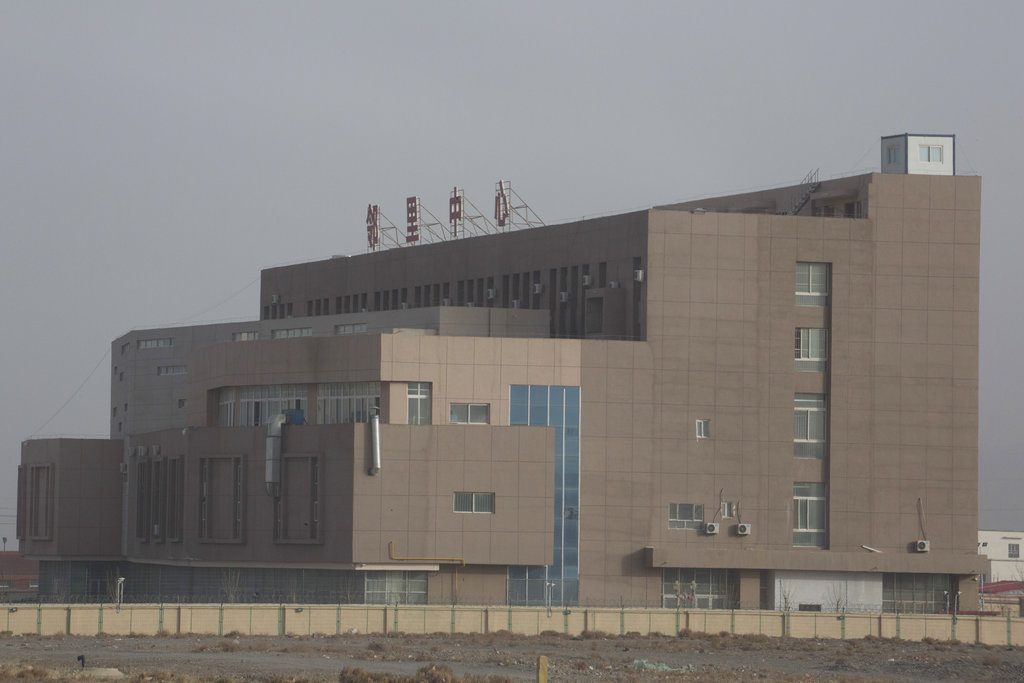 A building with the words "Neighborhood Center" at the top is seen Dec. 3 behind barbed wire fences in the Artux City Vocational Skills Education Training Service Center at the Kunshan Industrial Park in Artux in western China's Xinjiang region. Photo: Ng Han Guan / Associated Press