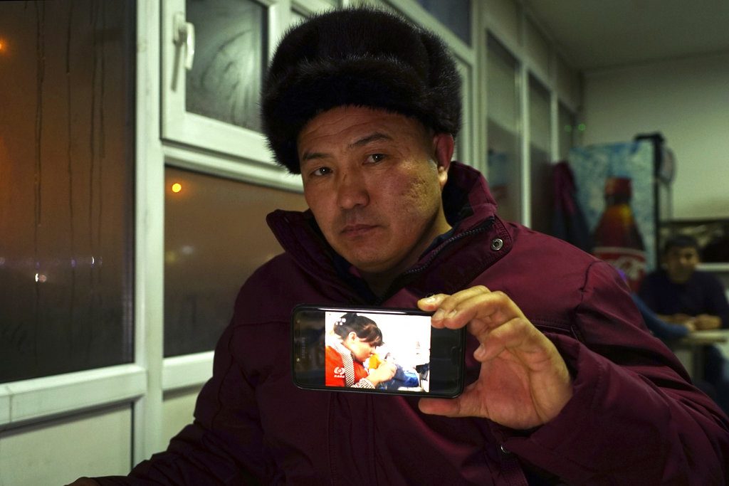 Orynbek Koksebek, a former detainee in a Chinese internment camp, holds up a phone Dec. 9 showing a state television report about what Beijing calls "vocational training centers" for a photo in a restaurant in Almaty, Kazakhstan. Photo: Dake Kang / Associated Press