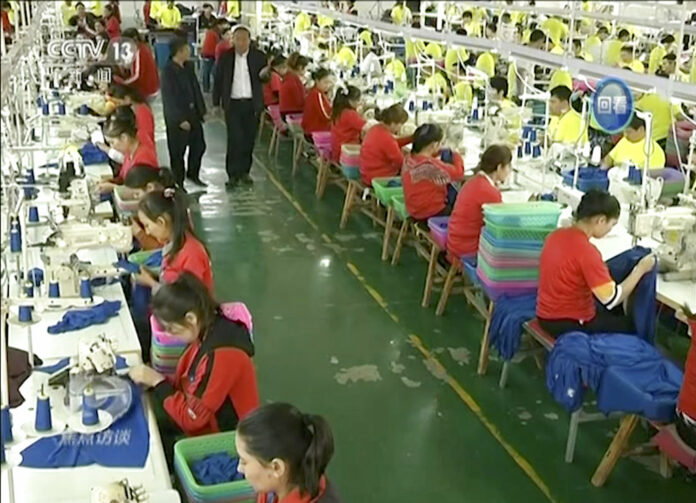 In this file image from undated video footage run by China's CCTV via AP Video, Muslim trainees work in a garment factory at the Hotan Vocational Education and Training Center in Hotan, Xinjiang, northwest China. Image: Associated Press
