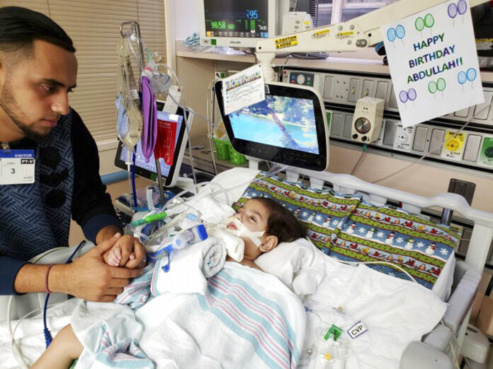 This recent but undated photo, released Monday, shows Ali Hassan with his dying 2-year-old son Abdullah in a Sacramento, California hospital. Photo: Associated Press