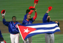 MLB, Union, Cuba Reach Deal for Players to Sign Members of the Cuban baseball team carry their country's flag onto the field in 1999 after a baseball game against the Baltimore Orioles at Camden Yards in Baltimore. Photo: Nick Wass / Associated Press