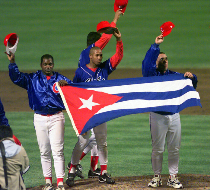 Members of the Cuban baseball team carry their country's flag onto the field in 1999 after a baseball game against the Baltimore Orioles at Camden Yards in Baltimore. Photo: Nick Wass / Associated Press
