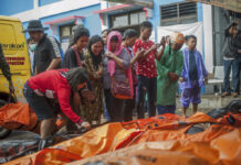 Somber Christmas, Prayers in Tsunami-Hit Indonesian Region People search for relatives Sunday among the bodies of tsunami victims in Carita, Indonesia. Photo: Fauzy Chaniago / Associated Press