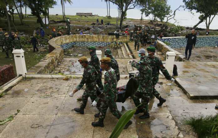 Indonesian soldiers carry the bodies of tsunami victims Monday at a beach resort in Tanjung Lesung Indonesia. Photo: Achmad Ibrahim / Associated Press