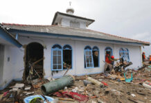 Indonesia Asks People to Avoid Coast Near Erupting Volcano People clean up a mosque Tuesday following the tsunami in Sumur, Indonesia. Photo: Tatan Syuflana / Associated Press
