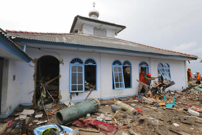 People clean up a mosque Tuesday following the tsunami in Sumur, Indonesia. Photo: Tatan Syuflana / Associated Press