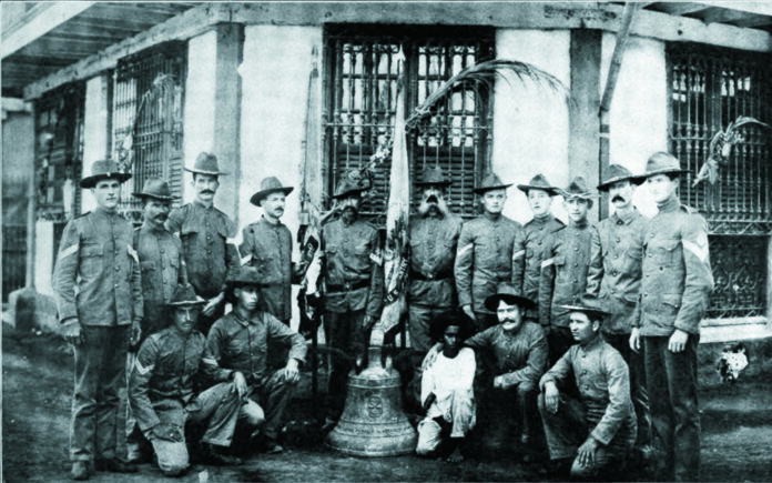 U.S. soldiers of Company C, 9th Infantry Regiment who survived a Filipino ambush in 1901 pose with a church bell used to signal the attack. Photo: Fred R. Brown / Wikimedia Commons U.S. soldiers of Company C, 9th Infantry Regiment who survived a Filipino ambush in 1901 pose with a church bell used to signal the attack. Photo: Fred R. Brown / Wikimedia Commons
