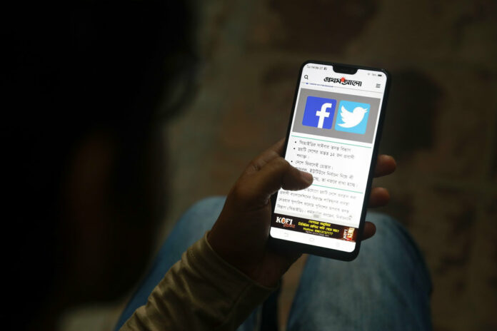 A Bangladeshi reads a news report that mentions Facebook along with other social networking service, on his mobile phone on Thursday in Dhaka, Bangladesh. Photo: AP A Bangladeshi reads a news report that mentions Facebook along with other social networking service, on his mobile phone on Thursday in Dhaka, Bangladesh. Photo: AP