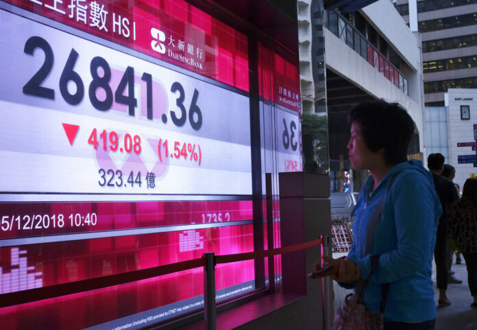 A woman looks at an electronic board showing Hong Kong share index outside a local bank Wednesday in Hong Kong. Photo: Vincent Yu / Associated Press