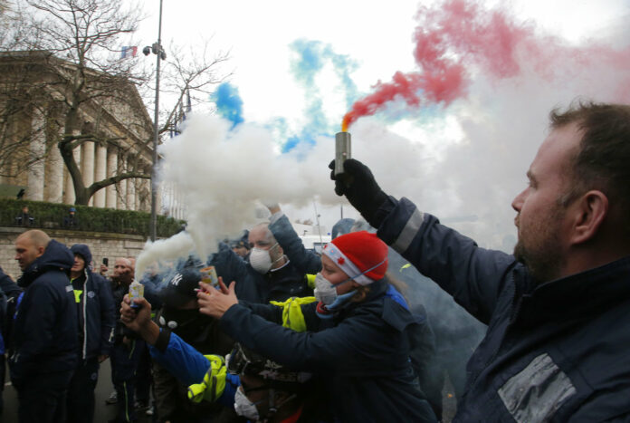 Ambulance workers hold flares Monday outside the National Assembly in Paris. Photo: Michel Euler / Associated Press