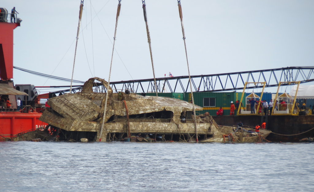 A crane boat raises the tour boat named the Pheonix from the sea floor in Phuket on Nov. 17, 2018.