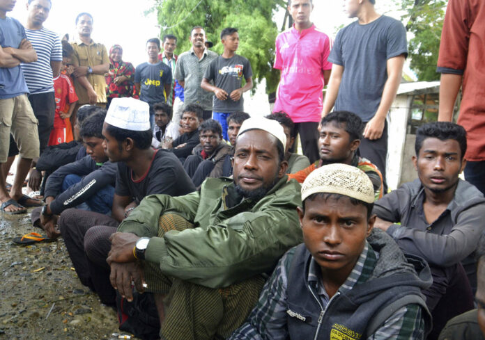 Rohingya men who were rescued by local fishermen sit on the ground Tuesday in Kuala Idi, Aceh province. Photo: Iskandar Ishak / Associated Press
