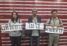 Case Against Academics Who Defied Assembly Ban Dropped Pakawadee Veerapaspong, left, and two others hold placards in 2017.