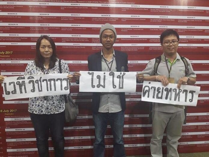 Pakawadee Veerapaspong, left, and two others hold placards in 2017.
