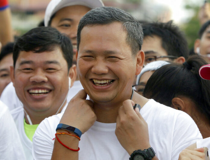 Lt. Gen. Hun Manet, at center, of the Royal Cambodian Armed Forces and the first son of Prime Minister Hun Sen, smiles before the start of the international half-marathon in June 2016 in front of Royal Palace in Phnom Penh. He is now 41. Photo: Heng Sinith / Associated Press