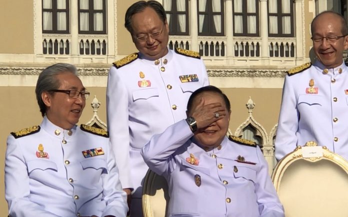 Gen. Prawit Wongsuwan raises a hand to shield his eyes from sunlight Dec. 4, 2017, in a cabinet photoshoot at the Government House which launched a scandal over the many multi-million baht, ultra-luxury timepieces he often wears.