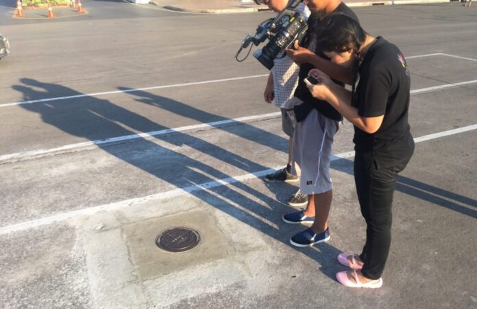Reporters take pictures of the new plaque replacing the one marking 1932 revolution.
