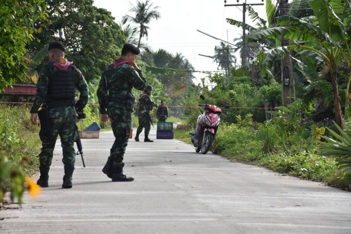 Soldiers investigate the area where an abandoned motorcycle was found Friday they believe was used by gunmen who killed four paramilitary officers in a Pattani school earlier this week. Soldiers investigate the area where an abandoned motorcycle was found Friday they believe was used by gunmen who killed four paramilitary officers in a Pattani school earlier this week.