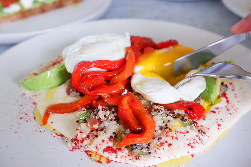 Two poached eggs on hummus, topped with pickled red pepper (290 baht)