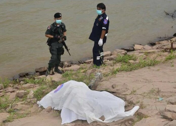 Police stand over one of the mutilated bodies retrieved from the Mekong river in December in Nakhon Phanom province.