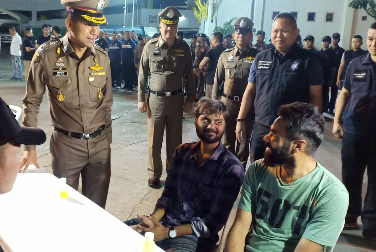 Two foreigners react as Lt. Gen. Surachate Hakparn looks on Friday morning at Bangkok’s Montien Riverside Hotel.