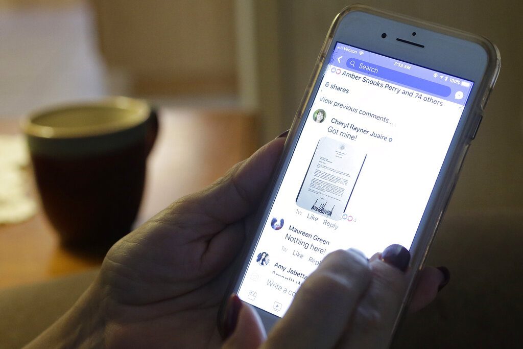 Cheryl Juaire, who lost her 23-year-old son to an opioid overdose in 2011, uses her phone to communicate with a group of other parents who have lost their children to overdoses, at her home in June in Marlborough, Massachusetts. Photo: Steven Senne / Associated Press