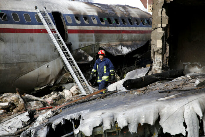 An Iranian rescue works Monday at the site of a Boeing 707 cargo plane crash, at Fath Airport about 40 kilometers (25 miles) west of Tehran, Iran. Photo: Hasan Shirvani / Associated Press