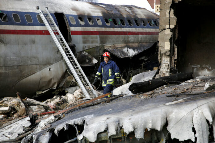 An Iranian rescue works Monday at the site of a Boeing 707 cargo plane crash, at Fath Airport about 40 kilometers (25 miles) west of Tehran, Iran. Photo: Hasan Shirvani / Associated Press An Iranian rescue works Monday at the site of a Boeing 707 cargo plane crash, at Fath Airport about 40 kilometers (25 miles) west of Tehran, Iran. Photo: Hasan Shirvani / Associated Press