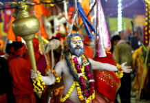 Asia This Week in Photos: Cute Pandas, Smog and Aussie Open A Hindu holy man dances holding a mace Tuesday as he arrives for a ritualistic dip on auspicious Makar Sankranti day during the Kumbh Mela, or pitcher festival in Prayagraj, Uttar Pradesh state, India. Photo: Rajesh Kumar Singh / Associated Press