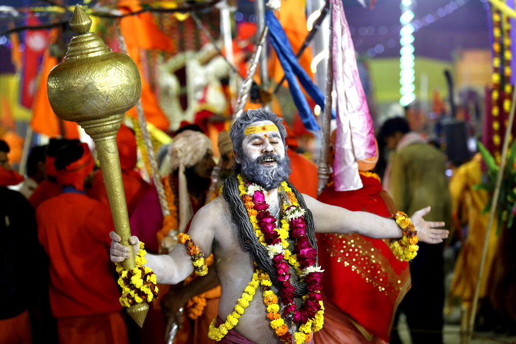 A Hindu holy man dances holding a mace Tuesday as he arrives for a ritualistic dip on auspicious Makar Sankranti day during the Kumbh Mela, or pitcher festival in Prayagraj, Uttar Pradesh state, India. Photo: Rajesh Kumar Singh / Associated Press