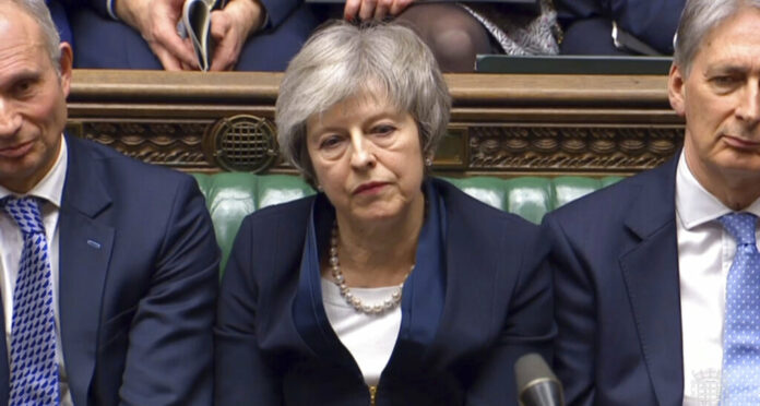 In this grab taken from video, Britain's Prime Minister Theresa May listens to Labour leader Jeremy Corbyn speaking Tuesday after losing a vote on her Brexit deal, in the House of Commons, London. Photo: Associated Press