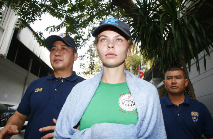 Thai Immigration police officers on Thuesday escort Belarusian model Anastasia Vashukevich, center, from the Immigration Detention Center towards a vehicle to take her to an airport for deportation in Bangkok. Photo: Sakchai Lalit / Associated Press