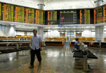 Stocks Slip on Worries Over Chinese Outlook, Huawei Probe An investor walks in front of stock trading boards at a private stock market gallery Thursday in Kuala Lumpur, Malaysia. Photo: Yam G-Jun / Associated Press
