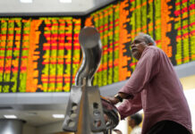 Asian Shares Shrug Off Wall St Losses as China Ends Congress A visitor stands in front of stock trading boards at a private stock market gallery in Jaunary Kuala Lumpur, Malaysia. Photo: Yam G-Jun / Associated Press