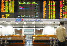 Asian Stocks Slip on Huawei Charges as Trade Talks Loom A visitor stands in front of stock trading boards at a private stock market gallery Thursday in Kuala Lumpur, Malaysia. Photo: Yam G-Jun / Associated Press