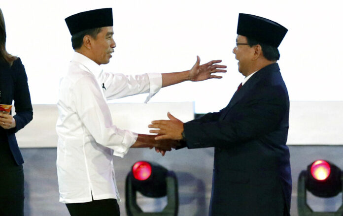 Indonesian President Joko Widodo, left, and his contender Prabowo Subianto, shake hands after a televised debate Thursday in Jakarta, Indonesia. Photo: Tatan Syuflana / Associated Press