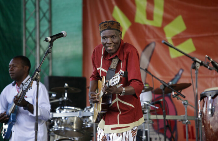 Zimbabwean music superstar and U.N. goodwill ambassador Oliver Mtukudzi, center, performs in 2011 at a music festival held in Karen on the outskirts of Nairobi, Kenya. Photo: Ben Curtis / Associated Press