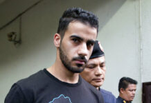 Aussie Envoy Mum on His Role in Hakeem Arrest Prison guards escort Bahraini football player Hakeem AlAraibi in December from a court in Bangkok. Photo: Gemunu Amarasinghe / Associated Press
