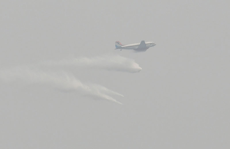 A plane drops water Tuesday afternoon over Chatuchak. 