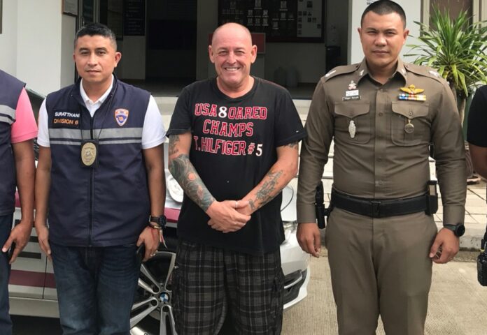 Gary Coughlan stands between two police officers Jan. 16 on Koh Samui after police accused him of cooking tom yum goong with cannabis.
