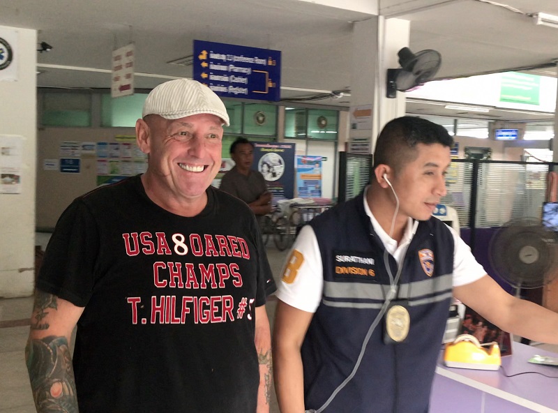 Gary Coughlan, left, walks beside a police officer Wednesday on Koh Samui.