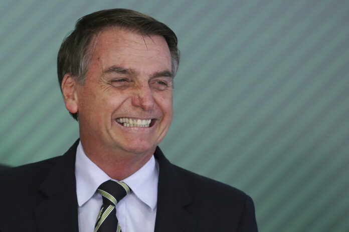 Brazil's President Jair Bolsonaro smiles during a ceremony where he signed a decree loosening restrictions on owning firearms Tuesday at Planalto presidential palace in Brasilia, Brazil. Photo: Eraldo Peres / Associated Press