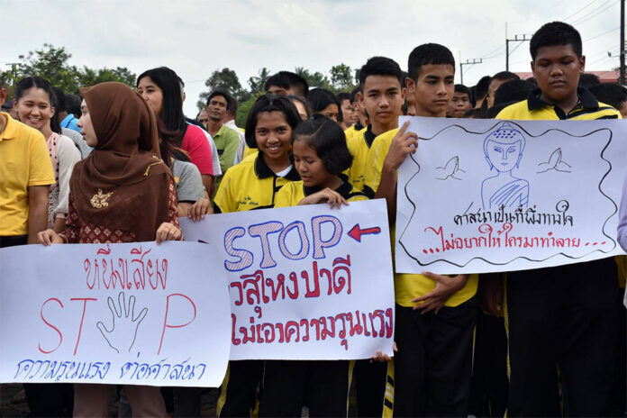 Buddhists and Muslims march Tuesday to protest attacks on civilians in Narathiwat province.