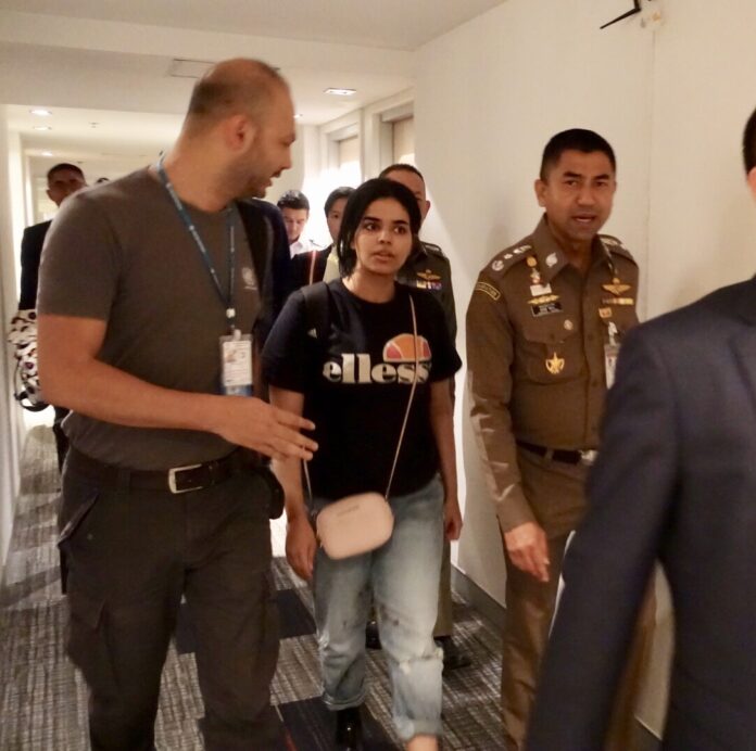 Rahaf Alqunun, at center, is escorted by immigration chief Surachate Hakparn, at right, Monday at Bangkok's Suvarnabhumi Airport. Rahaf Alqunun, at center, is escorted by immigration chief Surachate Hakparn, at right, Monday at Bangkok's Suvarnabhumi Airport.