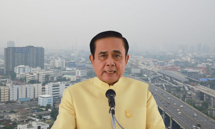 Gen. Prayuth Chan-ocha speaks Tuesday in Lampang, juxtaposed over a background of Bangkok’s smog.