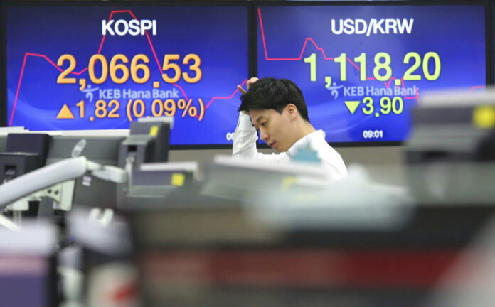 A currency trader watches monitors at the foreign exchange dealing room of the KEB Hana Bank headquarters Thursday in Seoul, South Korea. Photo: Ahn Young-joon / Associated Press