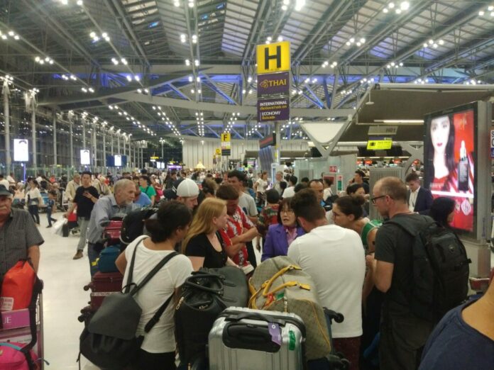 Passengers talk to a Thai Airways staff member Wednesday night at Suvarnabhumi International Airport.