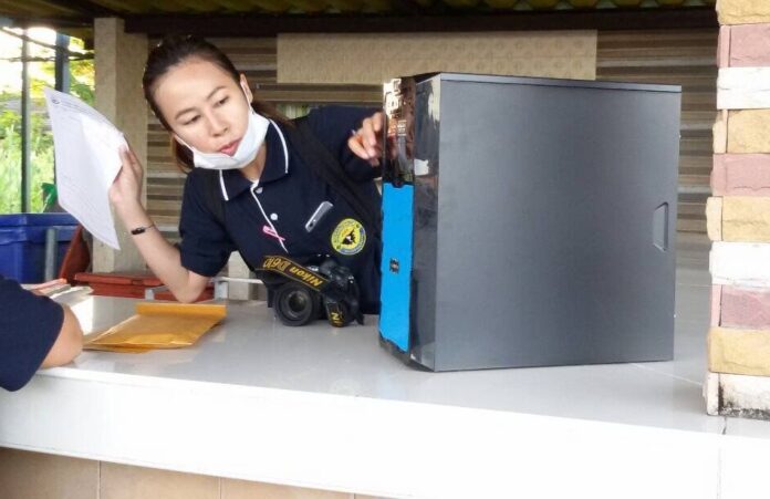 A DSI officer inspects a computer seized during a 2016 raid on a gambling den in Pattani province.